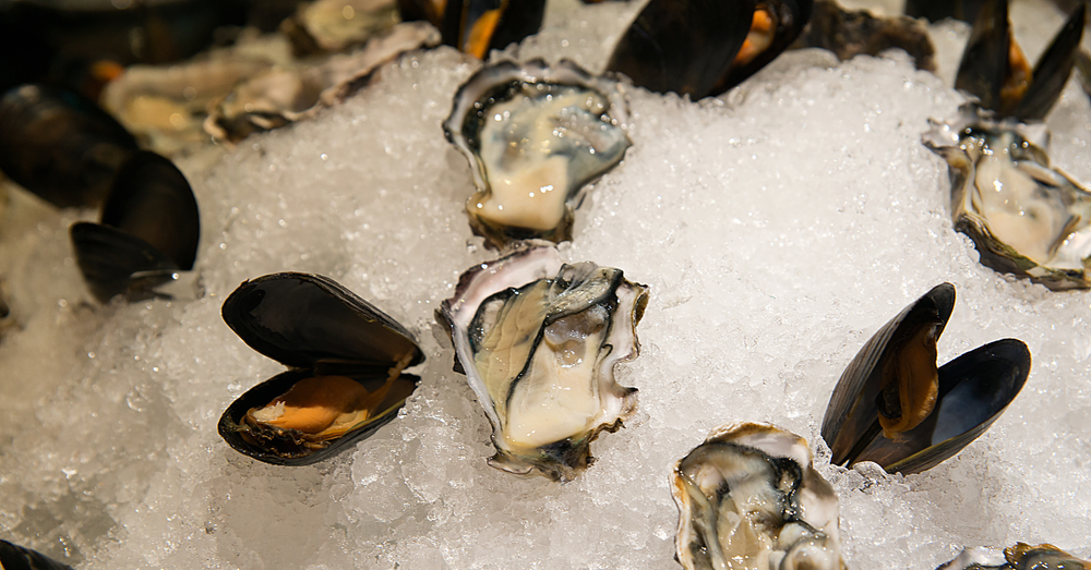 Image showing raw oysters and mussels with lemon juice drizzled on top.